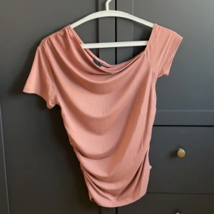 Rosa/Brun offshoulder topp, Gina Tricot - Säljer en snygg offshoulder topp i rosa/brun från Gina Tricot. (Aldrig använd, förutom när jag tog bilden). Är i storlek M men skulle även passa en S. Toppen har kort ärm, draperad effekt på sidorna. Skriv vid frågor eller intresse. Pris kan diskuteras 💗