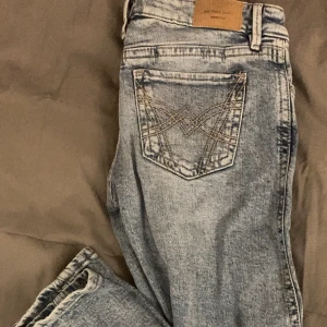 Low waist bootcut jeans - Säljer ett par ljusblå bootcut jeans från Perfect Jeans med snyggt broderi på bakfickan. Dom är knappt andvända, imprinssip nya, köpta från Gina tricot i strl 34.