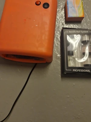 Full Beauty akrylgel och nagelkit - Säljer ett komplett akrylgel-kit med svart tub från Full Beauty, UV/LED-kompatibel, 15 ml. Ingår även ett set med transparenta lösnaglar i olika storlekar, en orange UV-lampa och ett akryl nagelsystem med flera burkar och flaskor. Perfekt för att fixa snygga naglar hemma. Skaer har tydlig tevken på användning men går fortfarande att använda som ny. Pris kan diskuteras!