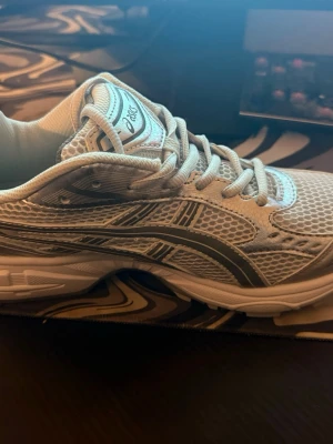 Vita Asics sneakers       - Säljer ett par fräscha vita Asics sneakers med grå detaljer och klassisk logga på tungan. Skorna har mesh-överdel för bra ventilation och snygga linjer längs sidorna. Platt sula och rund tå, perfekt för dig som gillar sportig stil och komfort.   Pris kan diskuteras !! 