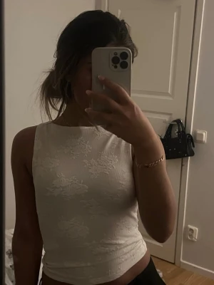 Vit blommig ärmlös linnetopp - Säljer en vit ärmlös linnetopp med subtilt blommigt mönster. Använd en gång 🌸 