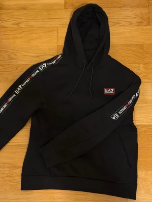 Emporio Armani 600kr - Hejsan! Säljer min Emporio Armani hoodie då den har blivit lite för liten för mig! Är några månader gammal men har inte används jättemycket. Kostar ca 1600kr ny!   Min mamma varit försiktig med tvättning! Den har inga hål eller skador och färgen har inte blekt någonstans! Den är storlek M men passar lite  bättre på S!   Finns i Eslöv om man vill mötas upp!