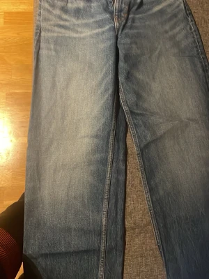 Blå jeans från Weekday straight fit - Säljer ett par blå jeans från Weekday med klassisk straight fit och snygga slittningar.