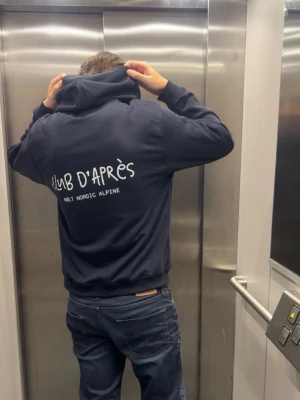 CLUB D’APRÈS Hoodie - Club d’Après - den perfekta hoodien för afterski, stadsliv och allt däremellan. Simpel, mjuk och stilren.