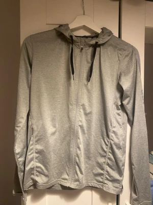 Grå träningsjacka - Grå vindjacka från 242 med hel dragkedja och svart snörning i huvan. Perfekt för träning och att ha över en annan tröja. Inte använd mycket så i bra skick!🫶🏼