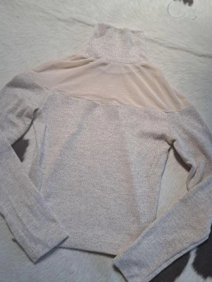 Beige polotröja med meshdetalj - Pris kan diskuteras!!❤️Trendig beige polotröja med lång ärm och transparent meshparti över axlar och bröst. Tröjan är stickad i mjukt material och har en hög polokrage som ger en snygg siluett. Perfekt för dig som vill ha en unik och stilren look.
