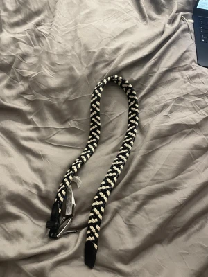 svart och vit flätade skärp  - säljer en unik svart och vit flätad bälte med ett coolt mönster, perfekt för dig som vill sticka ut med din stil!