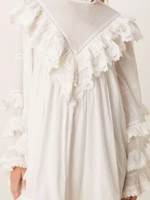 Vit volangklänning med spetsdetaljer - Supersöt vit kortklänning med volanger och spetsdetaljer. Klänningen har långärmade ärmar med flera lager volanger och små prickar i tyget. Perfekt för dig som gillar romantisk och bohemisk stil.