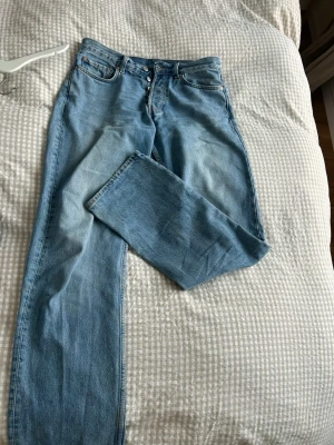 Weekday Space Straight Jeans ljusblå - Ljusblå jeans från Weekday, modell Space, med rak passform och klassisk femficksdesign. Jeansen har knappgylf och kontrastsömmar, tillverkade i bomull. Perfekt för dig som gillar en chill och enkel stil.