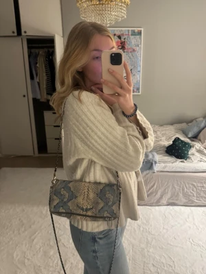 Unik Zadig väska i ormskinn  - Säljer min snygga och unika Zadig väska i blå, beige färg. Passar till allt och är otroligt snygg. Passar att ha båda kedjorna längst axeln eller en. Här används ordentligt därav kedjorna tappat lite färg och väskan (se bild) ❤️‍🔥❤️‍🔥❤️‍🔥