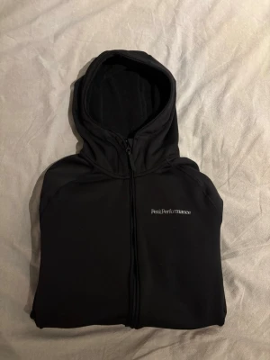 Svart Peak Performance hoodie - Svart hoodie som passar till allt. Inte använd mycket alls. Mycket skönt material. 