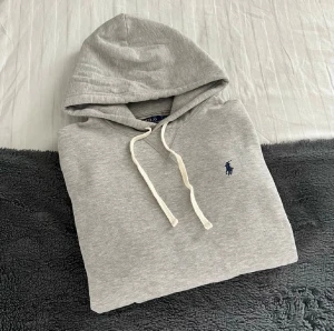 Grå Ralph Lauren Hoodie  - Schysst grå Ralph Lauren Hoodie i storlek M. Passar som en M eller en större S. Fint skick, mjuk och härlig tröja perfekt till vintern!⛄️hör av er vid funderingar🙌