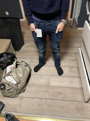 Handpicked blå jeans med slim fit - Snygga mörkblå jeans från Handpicked, tillverkade i Italien. Skinny fit med låg midja och coola detaljer som en unik bakficka med svartvit mönster. Materialet är mestadels bomull med lite polyester och elastan för stretch. Perfekt för dig som gillar stilrena och moderna jeans.