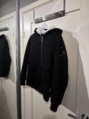 Moose Knuckles jacka  - Säljer en svart pufferjacka från Moose Knuckles i storlek XL i barn och XS i vuxen. Jackan har huva med vit fuskpäls, quiltad insida med logomönster och dragkedja framtill. Snygg patch på ärmen och stora fickor framtill. sopren vibe och riktigt varm. Kvitto finns 