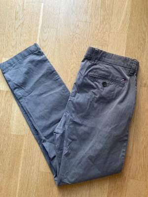 Tommy Hilfiger grå chinos - Ljusgrå Tommy Hilfiger chinos slim fit.  Storlek 32/32.  Något urtvättade men i övrigt bra skick.  97 % bomull, 3 % elastan.   