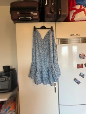 Blommig blå klänning från Odd Molly - Supersöt lång kjol från Odd Molly i ljusblått med blommigt mönster i blått och beige. Klänningen har v-ringning, volangdetaljer och är ärmlös. Perfekt för sommarens alla tillfällen. Materialet är mjukt och luftigt, troligtvis bomull. Storlek 6 som enligt deras storleksguide motsvarar en storlek XXL. Helt ny med tags/ prislapp fortfarande kvar. 