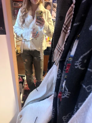 Vit pälsjacka med bälte och detaljer - Säljer en vit pälsjacka med fluffig krage och pälsdetaljer vid ärmslut och nederkant. Jackan har bälte i midjan och vid ärmarna, samt dubbla knappar framtill. Snygg och varm, perfekt för dig som vill sticka ut. Nästan helt oanvänd, därav priset, skriv gärna för mått❤️❤️