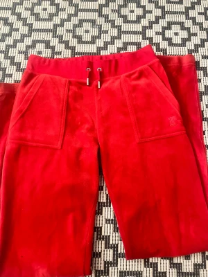 Juicy couture  - Röda juicy byxor, äkta och sparsamt använda! Storlek S, och perfekt inför julen. Endast använd deffekt längst ner vid benet som syns på sista bilden. Går nog att fixa med tvätt.