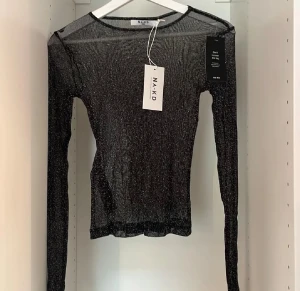 Glittrig svart mesh-top från NA-KD - En glittrig långärmad mesh topp. Aldrig använd med prislappen kvar, är från NA-KD. 