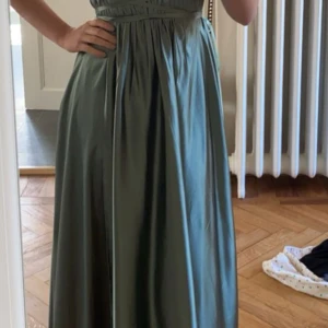 Grön långklänning med markerad midja - Balklänning använd 1 gång, köpte för tre år sen i pk huset vid nk. Jättebra skick och passar perfekt i längd för person ca 170cm