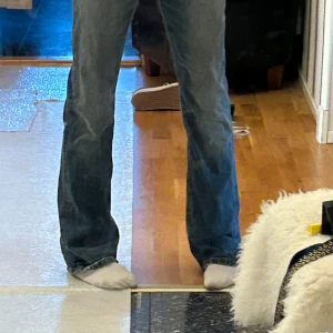 Blå baggy low waist bootcut jeans - Säljer ett par klassiska blå jeans med bootcut passform. Jeansen har en snygg tvätt och sitter skönt över höfterna innan de blir vidare nertill. Perfekta för dig som gillar en retrostil och vill ha ett par jeans som sticker ut lite extra.