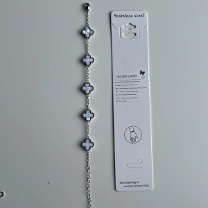 White Alhambra bracelet - Stilrent armband i silverfärgad stainless steel med fem vita klöverformade länkar. Varje klöver har en glansig yta och är infattad med små detaljer runt kanterna. Perfekt för dig som gillar minimalistisk och modern design. Mvh clover.se