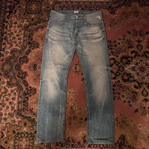 Replay anbass ljusblå slim jeans 30/32 - Säljer ett par ljusblå jeans från Replay med snyggt slitna detaljer och raka ben. Klassisk femficksmodell med broderade bakfickor och Replay-logga på fickan. Jeansen är i bomull och har normal passform, perfekt för en avslappnad stil. Midja 41cm längd 99cm (50)
