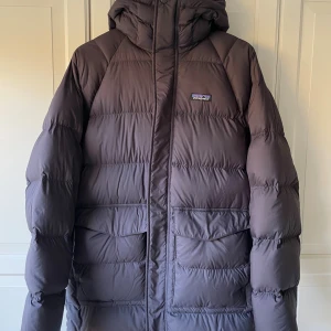 Patagonia parka silent down dunjacka - Patagonia dunparka, nästan oanvänd, mycket fint skick. Väldigt varm och mjuk.   En superskön jacka jag köpte ett år sedan från Outnorth, men den visade sig vara precis liiite för stor för mig, sitter mer som en Medium.  Passar bra på någon som är 175-185cm. Den heter ’black’ men är snarare mörkgrå/grafitgrå.  Det är denna jacka: https://tinyurl.com/2s362zcr  (Jag tror nypriset var strax under 4000kr för ett år sedan.)