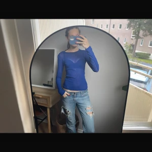 Blå långärmad topp från Monki - Säljer en tunn, långärmad topp från Monki i en klarblå färg. Modellen är figurnära med rund halsringning och är tillverkad i ett lätt, något transparent material som känns skönt mot huden. Perfekt att styla med jeans eller kjol för en cool look. ❤️Inte mina bilder❤️