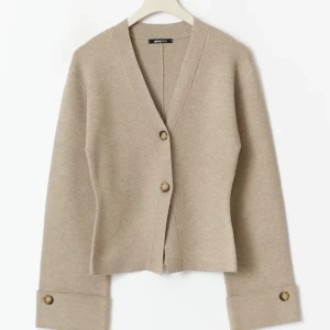 Beige kofta från Gina Tricot med knappar - Snygg beige kofta från Gina Tricot med v-ringad hals och två stora knappar framtill. Helt ny aldrig använd. Fick i present och hade inget kvitto 