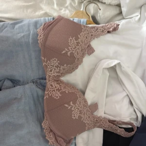 Rosa spets-bh från Intimissimi - Säljer en superfin rosa bh från Intimissimi med vacker spetsdetalj och blommönster. Bh:n har vadderade kupor och justerbara axelband. Perfekt för dig som vill ha något både snyggt och bekvämt. Några trådar som sticker ut från brodyren, men inget man tänker på direkt.