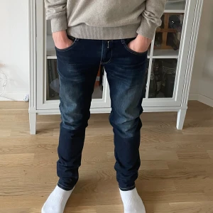 Mörkblå Replay Anbass W30 L34 - Jag säljer dom här riktigt fräscha Replay Anbass jeansen i storlek W30 L34. De är inte använda mycket alls och har inga skador eller defekter. Tveka inte att höra av er!                                         Mått: Längd=106cm. Midja=40cm