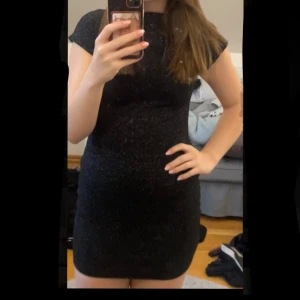 Svart glittrig nyårsklänning - Supersnygg svart kortklänning från Zara med glittriga detaljer. Klänningen har en tight passform, korta ärmar och är tillverkad i ett stretchigt syntetmaterial som sitter bekvämt. Storlek S. Perfekt till nyår. Endast använd 1 gång 