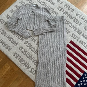 Grå ribbad långkjol från NA-KD - Säljer en snygg grå långkjol från NA-KD i storlek S. Kjolen är stickad med ribbad struktur och har en mjuk, loose passform. Perfekt för dig som gillar chill och comfy vibes. Materialet är stickat och färgen är ljusgrå, vilket gör den enkel att matcha med andra plagg.