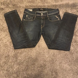 Replay mörkblå jeans slim fit - Snygga mörkblå jeans från Replay i en slim fit. Jeansen har kontrastsömmar, tydlig Replay-logga på bakfickan. Modellen är replay anbass som är slim fit. Kontakta vid funderingar.