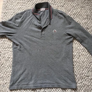 Grå långärmad pikétröja Moncler🤩🙌 - Säljer en grå långärmad pikétröja från Moncler med klassisk krage och knappar framtill i storlek S✅🙌