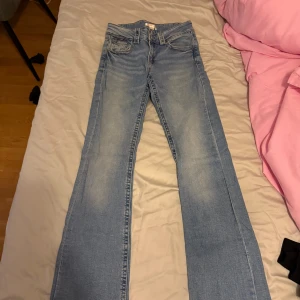 Blå jeans från Gina Tricot, storlek 170 - Snygga ljusblå jeans från Gina Tricot i storlek 170. Klassisk femficksmodell med raka ben och normal passform. Jeansen har en lätt tvättad look och är tillverkade i mjukt denimtyg med bruna sömmar. Perfekt för dig som gillar enkel och stilren denim.