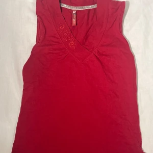 Vintage röd linnetopp från Carry - Snygg röd linnetopp från Carry i storlek XS. Den är vintage och ger en y2k vibe!🎀Toppen är ärmlös med v-ringad hals och har broderade detaljer vid halsringningen. Perfekt för dig som gillar enkel men stilren design.🥰🥰Pris kan diskuteras!☺️