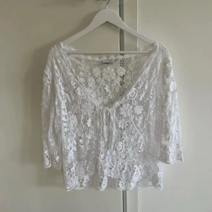 Vit spets kofta  - En vit spets kofta från Isolde. Den är i strl XL men skulle mer säga att den sitter som en L. Mycket bra skick!