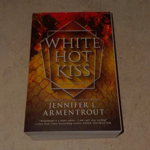 White Hot Kiss - En spännande bok med fantasyvibbar, perfekt för dig som gillar heta känslor och övernaturliga inslag. Omslaget har eld och drakliknande mönster som lockar till läsning. Passar unga vuxna som vill ha något riktigt fängslande.