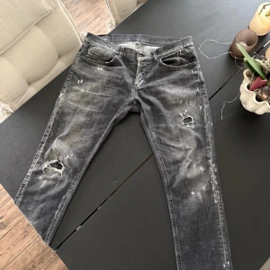 Dondup Jeans - Säljer ett par feta jeans från Dondup med coolt slitet och tvättat utseende, samt hål och slitningar på benen. Riktigt snygga detaljer och passar bra för dig som vill sticka ut lite! Bara att höra av sig för frågor!