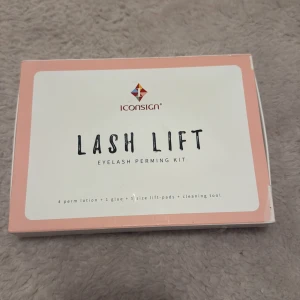 ICONSIGN Lash Lift Kit - Komplett lash lift kit från ICONSIGN med fyra olika lotions, lim, rengöring, näring, blå permvätska, samt lift pads i flera storlekar och rengöringsverktyg. Perfekt för att få snyggt böjda fransar hemma. Förpackningen är ljusrosa och vit med silvriga detaljer.