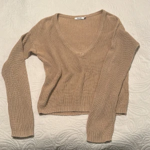 Beige stickad v-ringad tröja NA-KD - Säljer en beige stickad tröja från NA-KD i storlek S. Tröjan har v-ringad hals och långa ärmar. Den är sparsamt använd och inga fläckar eller skador. 