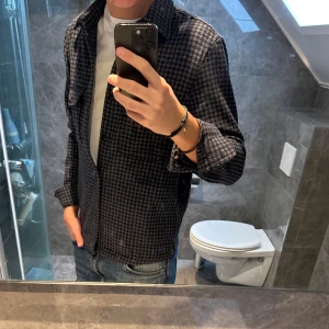 Mörkblå Overshirt med rutigt mönster - Snygg mörkblå overshirt med rutigt mönster och klassisk krage från mango. Den är i riktigt bra skick och passar perfekt till hösten. Den är i storlek S men passar även M. Jag är 188cm och den är något liten på mig. Hör av er vid funderingar:)