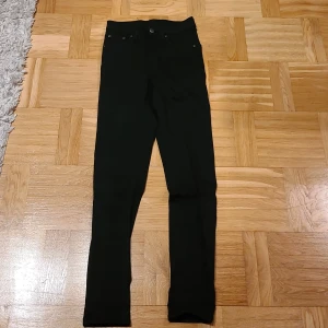 Svarta skinny jeans från Cheap Monday - Svarta jeans från Cheap Monday med klassisk femficksdesign och skinny passform. Hög midja och smala ben ger en snygg siluett. Jeansen är gjorda i stretchigt bomullsmaterial för extra komfort. Perfekt för dig som gillar en stilren och enkel look.