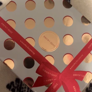 Estée Lauder hudvårdskit med lyxiga ikrämer - Säljer ett exklusivt hudvårdskit från Estée Lauder med Revitalizing Supreme+ krämer och Advanced Night Repair serum som jag själv lägger till . Setet innehåller burkar i guld och blått samt en tub, allt snyggt förpackat i en presentask med guldprickar och rött band. Perfekt för dig som vill boosta din hudrutin.