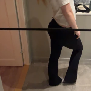 Svarta kostymbyxor från Bik Bok - Säljer dessa trendiga svarta bootcut-kostymbyxor från Bik Bok i storlek 34. Byxorna har låg midja och sitter som ett par tajts. Sparsamt använda☺️