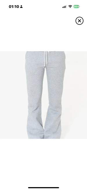 Grå bootcut mjukisbyxor  - Snygga grå mjukisbyxor med bootcut passform och vit snörning i midjan. Midjan är normal och byxorna har fickor på sidorna. 