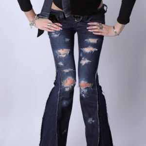 Unika lågmidjade bootcut vintage jeans med slitningar - Jättefina och unika lågmidjade jeans med slitningar. Jeansen är bootcut och har fina detaljer.   - Storlek: XS - Midjemått: 36 cm - Innerbenslängd: 80 cm - Modellen är 175 cm lång för referens  Jeansen är i jättebra skick och har inga defekter (vad vi märkt)!!  Vid frågor eller funderingar - tveka inte att höra av dig🪽