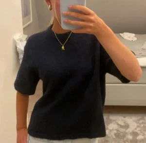 Mörkblå stickad tröja med kort ärm - Snygg mörkblå stickad tröja med rund hals och korta ärmar.